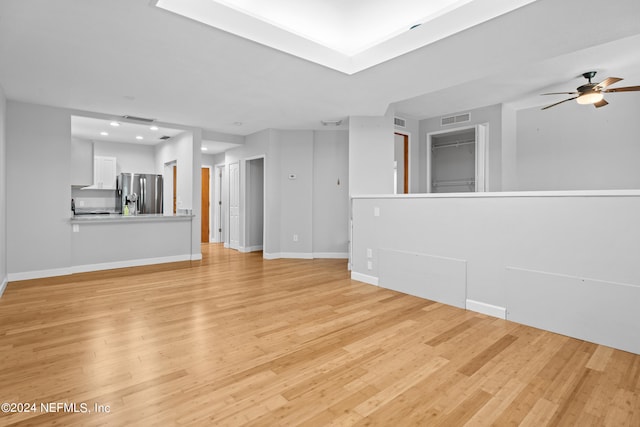 unfurnished living room with ceiling fan and light hardwood / wood-style flooring