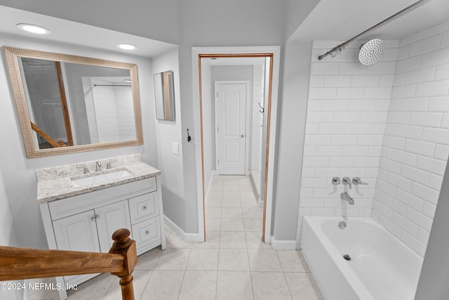 bathroom featuring tile patterned flooring, vanity, and tiled shower / bath