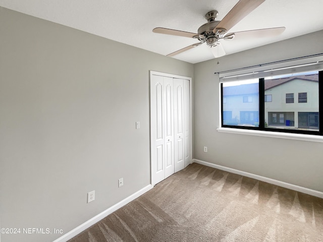 unfurnished bedroom featuring ceiling fan, a closet, and carpet