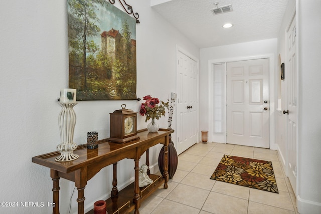 tiled entryway featuring a textured ceiling