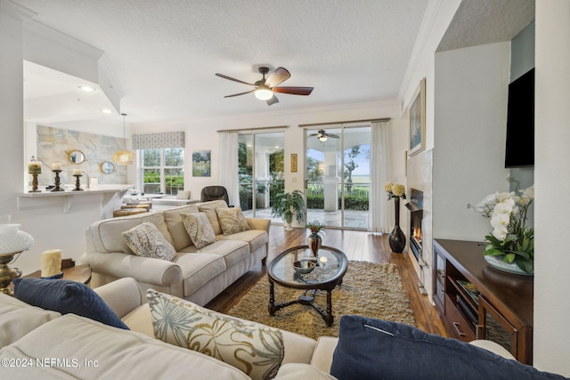 living room with hardwood / wood-style flooring, crown molding, and a textured ceiling