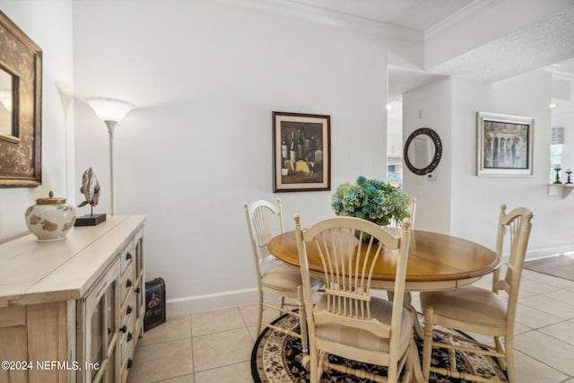 dining room with light tile patterned floors and crown molding