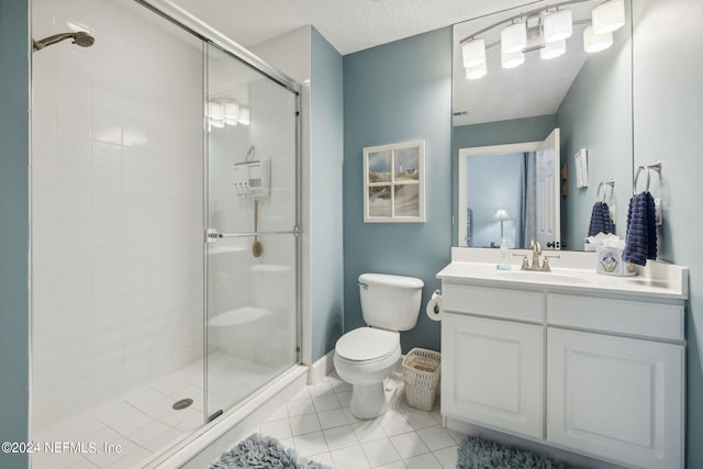 bathroom featuring tile patterned floors, walk in shower, vanity, a textured ceiling, and toilet