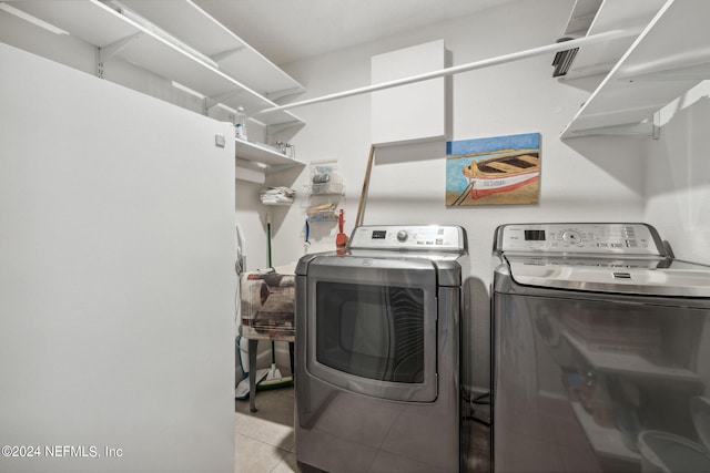 laundry room with separate washer and dryer and light tile patterned flooring