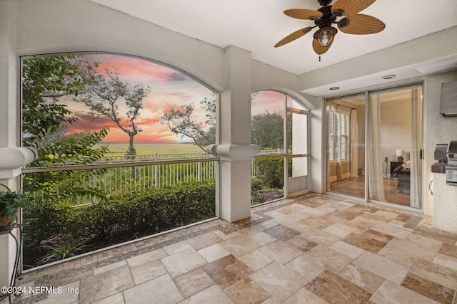 unfurnished sunroom featuring ceiling fan