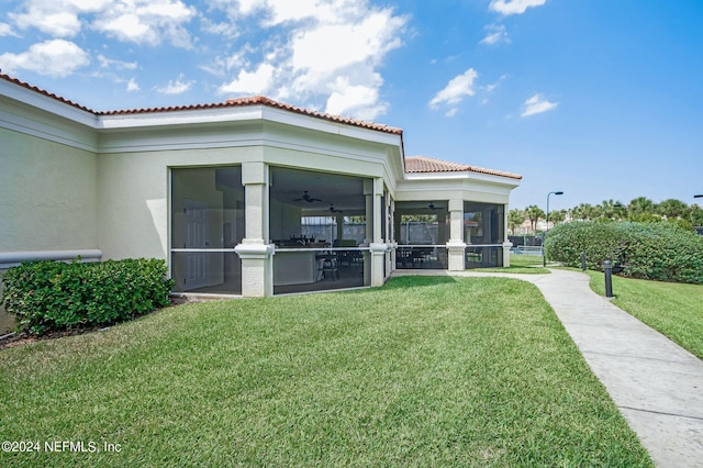 exterior space featuring a yard and a sunroom