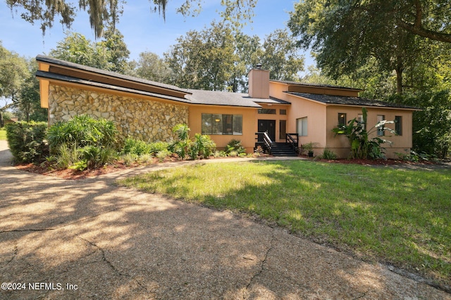 rear view of property featuring a lawn