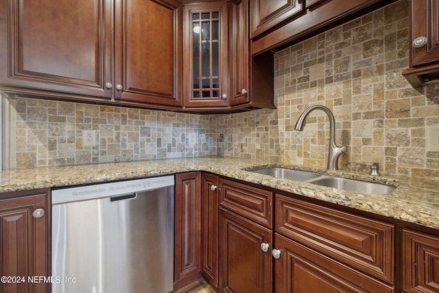 kitchen with sink, decorative backsplash, light stone countertops, and dishwasher