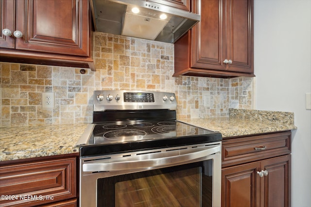 kitchen with light stone counters, stainless steel electric stove, tasteful backsplash, and exhaust hood