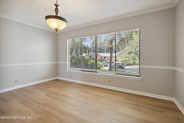 spare room featuring hardwood / wood-style flooring, ornamental molding, and a healthy amount of sunlight