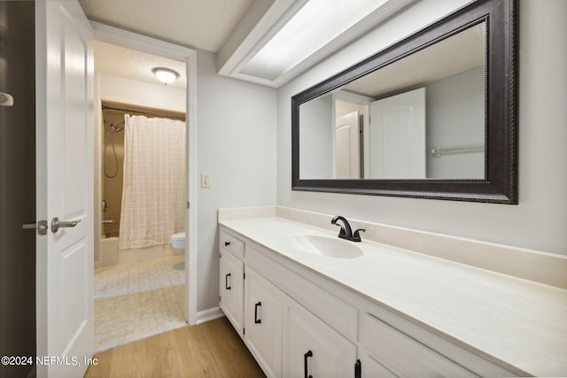 full bathroom with vanity, wood-type flooring, shower / bath combo, and toilet