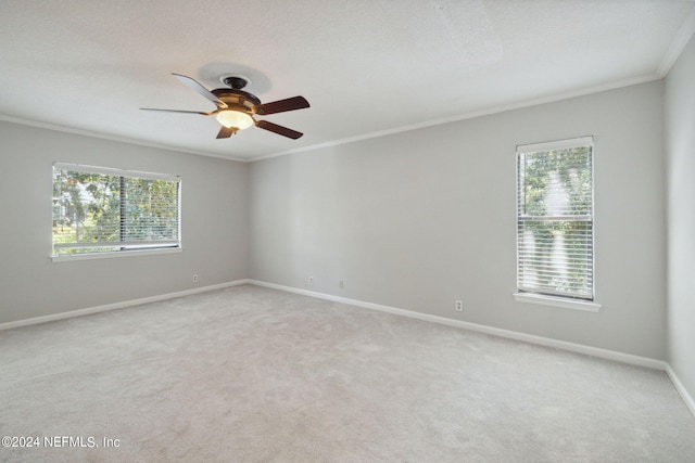 carpeted spare room featuring a textured ceiling, ornamental molding, and ceiling fan