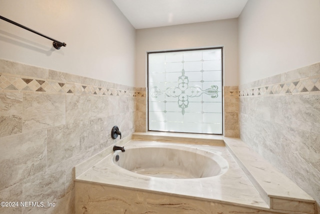 bathroom with a relaxing tiled tub