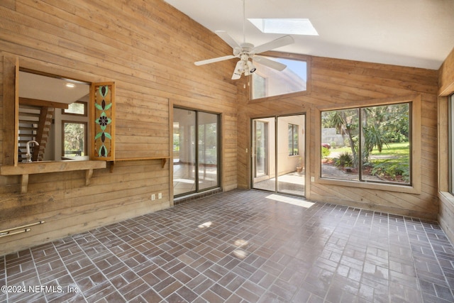 interior space featuring a skylight and wooden walls