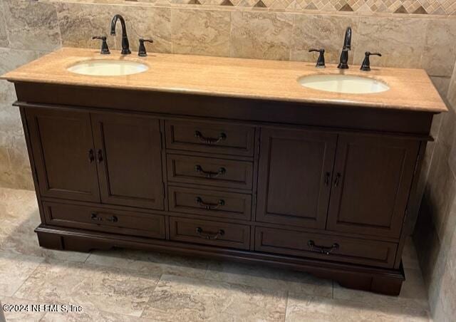 bathroom with vanity and tile walls