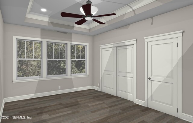 unfurnished bedroom with dark hardwood / wood-style floors, ceiling fan, a raised ceiling, and multiple closets