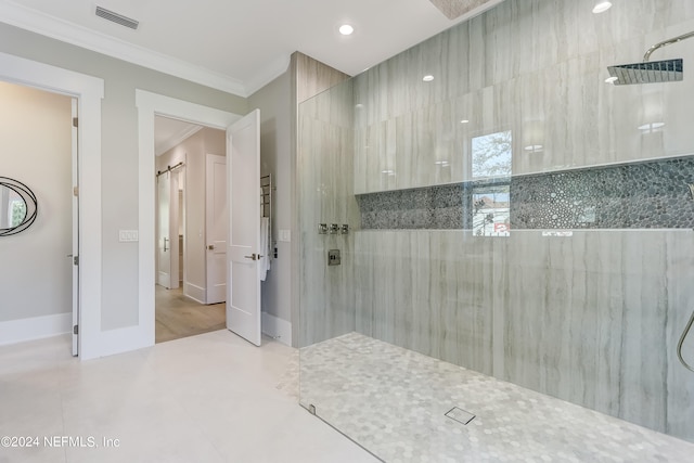 bathroom featuring tiled shower, tile flooring, and ornamental molding