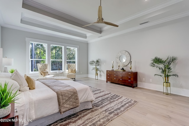 bedroom featuring a tray ceiling, crown molding, hardwood / wood-style flooring, and ceiling fan