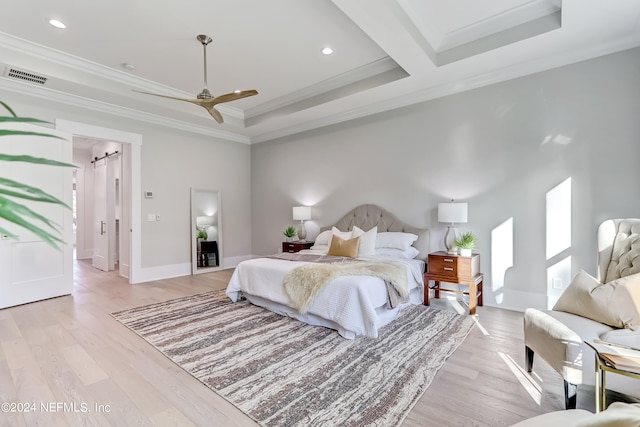 bedroom with a tray ceiling, ceiling fan, light hardwood / wood-style floors, and ornamental molding