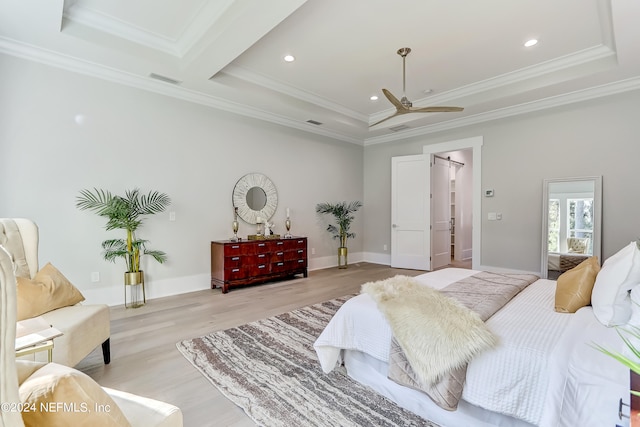 bedroom with a tray ceiling, crown molding, ceiling fan, and light hardwood / wood-style flooring