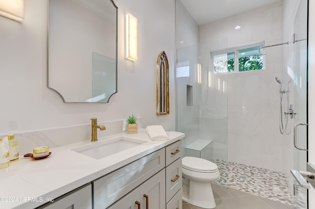 bathroom with a shower with shower door, toilet, tile floors, and large vanity