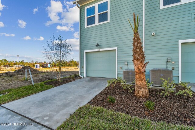 view of home's exterior featuring a garage and central AC unit