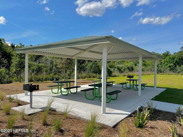 view of property's community featuring a gazebo, a lawn, and a patio