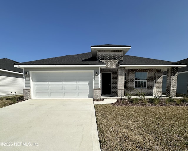 prairie-style home featuring a garage and a front lawn