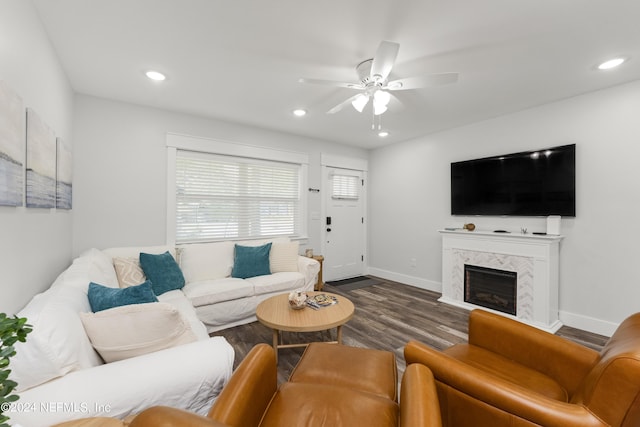 living room with dark hardwood / wood-style floors, ceiling fan, and a high end fireplace