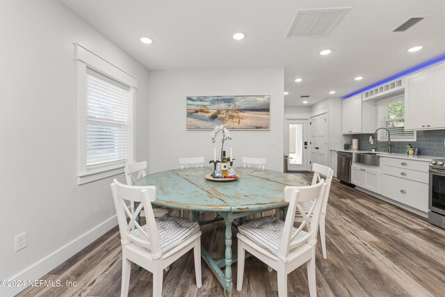 dining room with hardwood / wood-style floors and sink