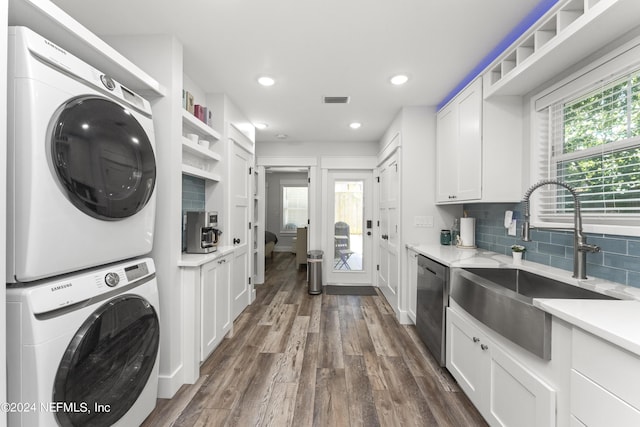 washroom with a healthy amount of sunlight, dark hardwood / wood-style flooring, stacked washer / drying machine, and sink