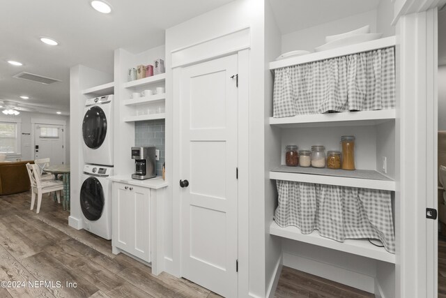 laundry area with hardwood / wood-style flooring, stacked washer / drying machine, and ceiling fan