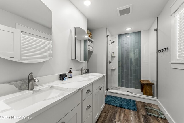 bathroom with hardwood / wood-style flooring, vanity, and a shower with shower door