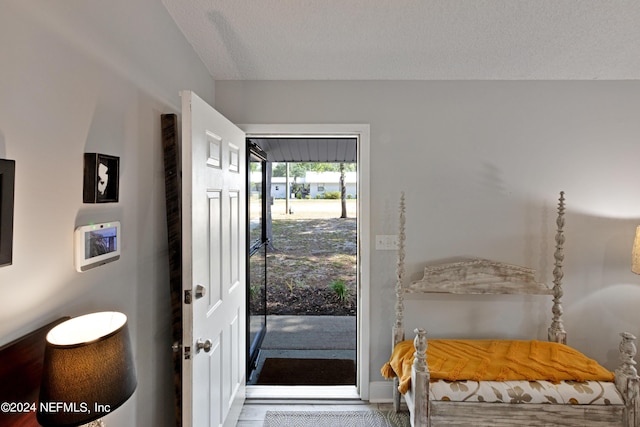 doorway to outside featuring a textured ceiling