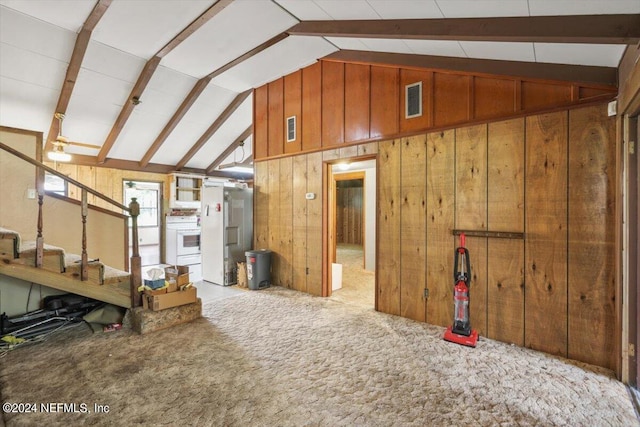 interior space featuring wooden walls, lofted ceiling with beams, and carpet floors