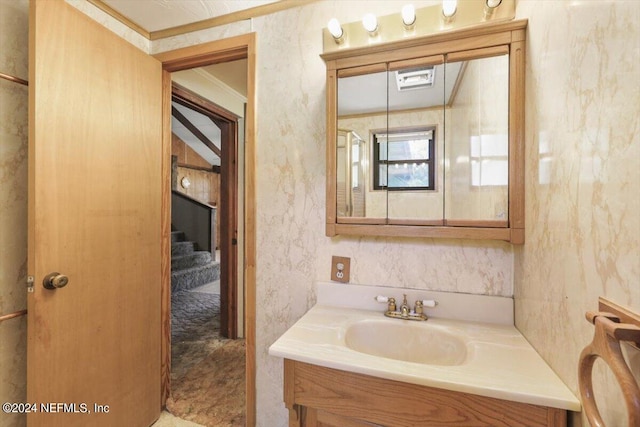 bathroom with ornamental molding and vanity