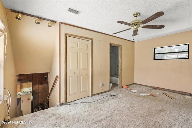 unfurnished bedroom with ceiling fan, carpet floors, and a textured ceiling