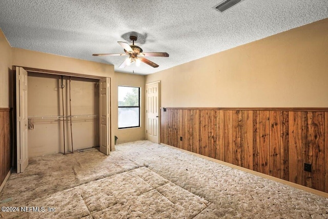 unfurnished bedroom with carpet flooring, ceiling fan, and a textured ceiling