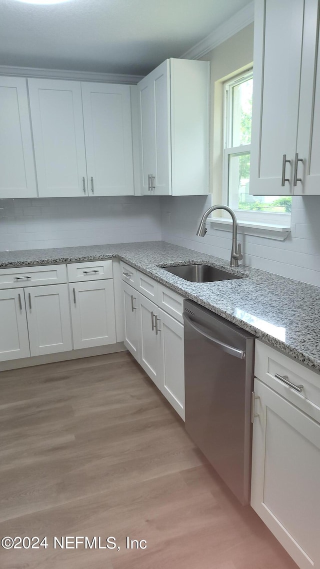 kitchen featuring white cabinets, light wood-type flooring, stainless steel dishwasher, and sink