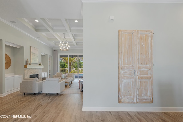 living room featuring ornamental molding, coffered ceiling, an inviting chandelier, beamed ceiling, and light hardwood / wood-style floors