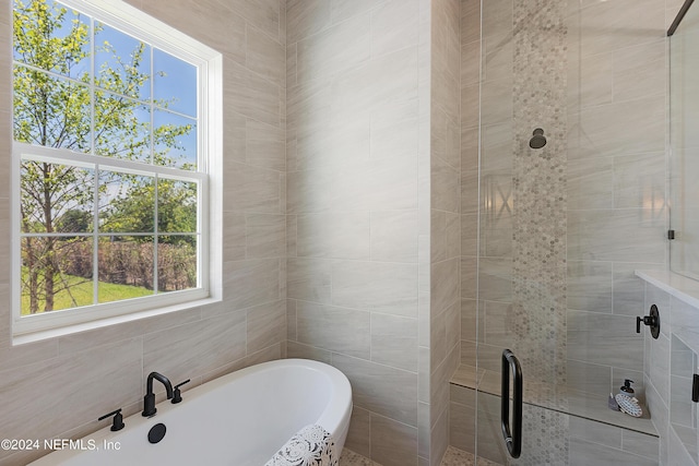 bathroom featuring shower with separate bathtub