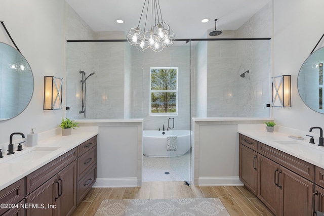 bathroom featuring hardwood / wood-style floors, vanity, shower with separate bathtub, and an inviting chandelier