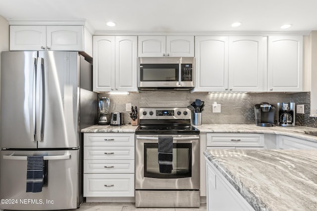 kitchen featuring appliances with stainless steel finishes, tasteful backsplash, and white cabinetry