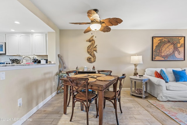 dining room featuring ceiling fan and sink