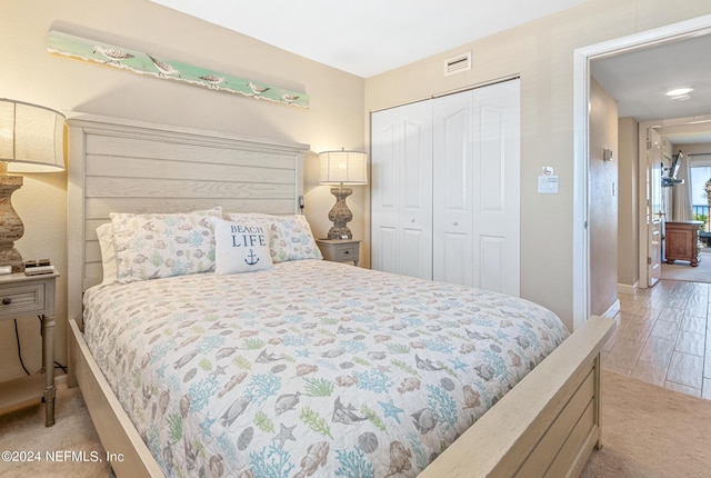 bedroom with light hardwood / wood-style floors and a closet