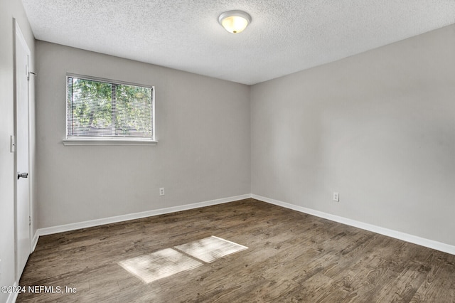 unfurnished room with hardwood / wood-style floors and a textured ceiling