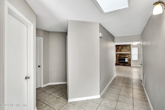 hallway featuring light tile patterned floors and a textured ceiling