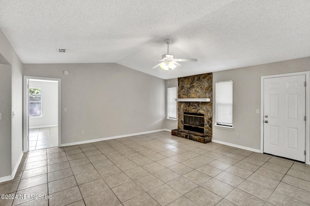 unfurnished living room with a fireplace, vaulted ceiling, ceiling fan, and light tile patterned flooring