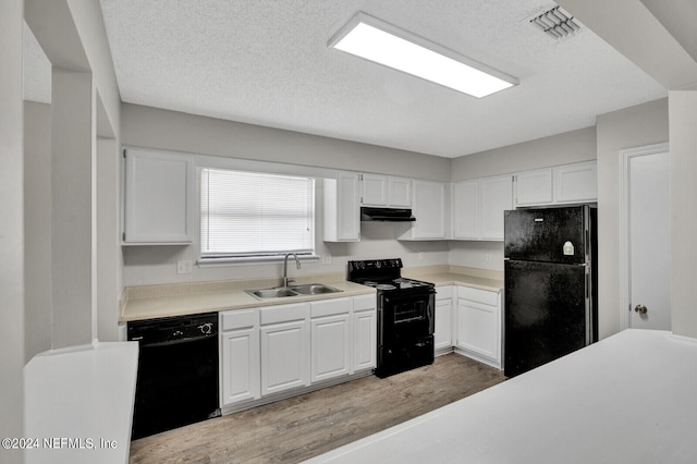 kitchen with white cabinets, light wood-type flooring, sink, and black appliances