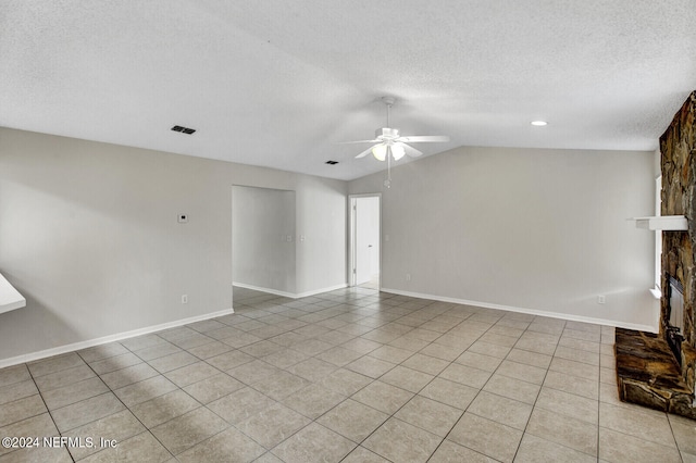 unfurnished living room with ceiling fan, a fireplace, light tile patterned flooring, and lofted ceiling